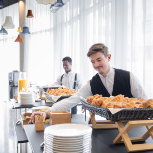 Deux employés du Kopster hotel en train de servir le petit dejeuner